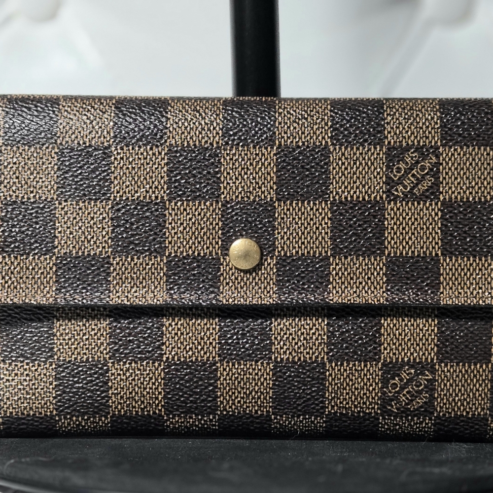 Louis Vuitton Sarah wallet in the Damier Ebene canvas.